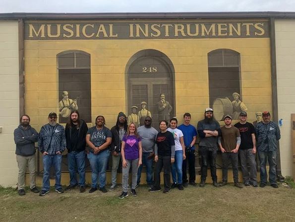 Members of the Gretsch Drums team in front of a new mural painted on the drum factory building.